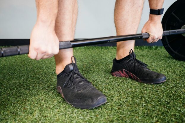 High school baseball player performing deadlifts to build lower-body strength.